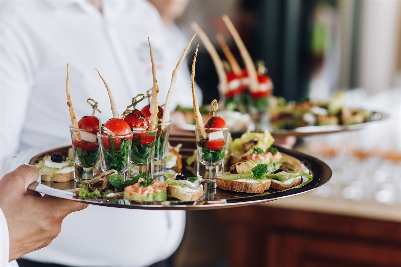 Camarero con bandeja de aperitivos servidos en un evento